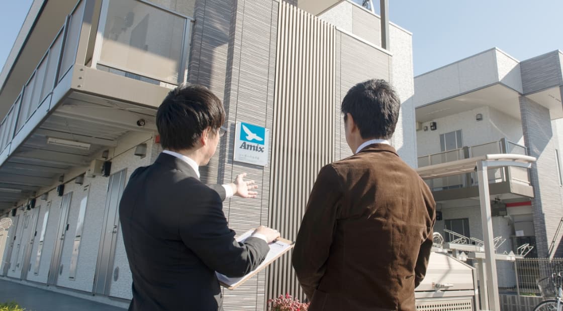 男性が男性にアパートを案内している写真